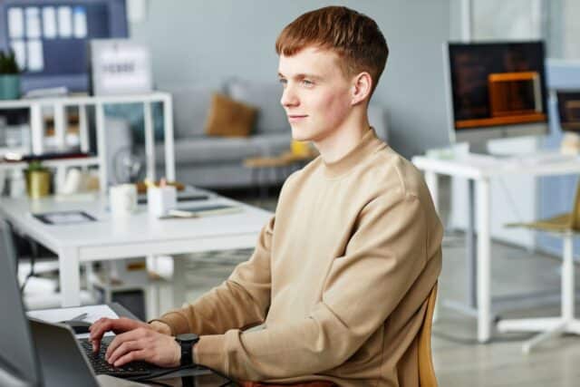 Jeune homme satisfait d'avoir écrit sa lettre de motivation pour un emploi