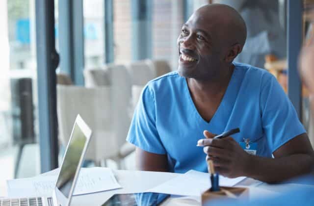 Etudiant heureux dé rédiger sa lettre de motivation pour devenir infirmer